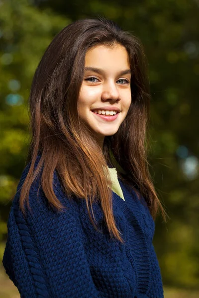 Linda niña morena posando en el fondo del parque de otoño —  Fotos de Stock