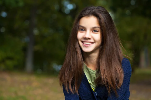 Bella bruna bambina in posa in autunno parco sfondo — Foto Stock