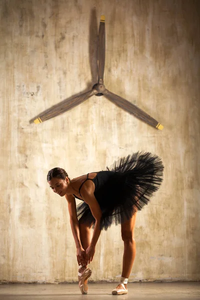 Mladá krásná baletka v černém baletu, která pózala v temných — Stock fotografie