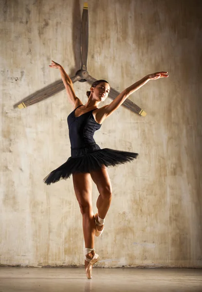 Young beautiful ballerina in black ballet tutu posing in dark st — Stock Photo, Image