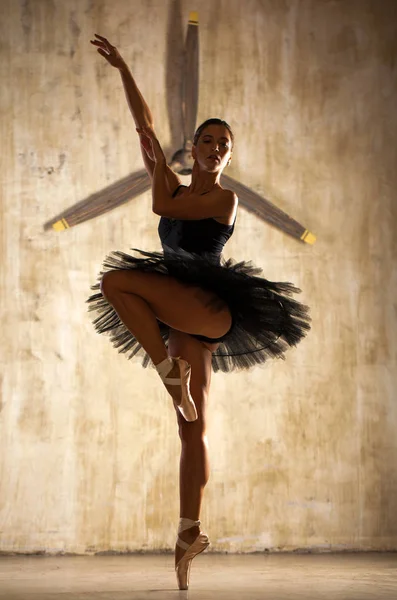 Jovem bela bailarina em preto tutu balé posando em st escuro — Fotografia de Stock