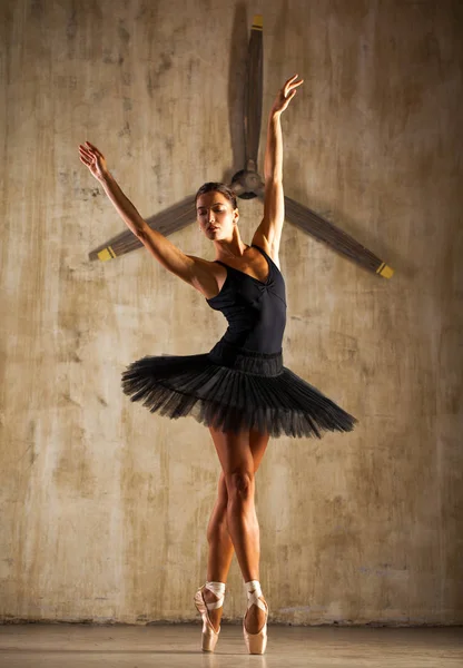 Jovem bela bailarina em preto tutu balé posando em st escuro — Fotografia de Stock