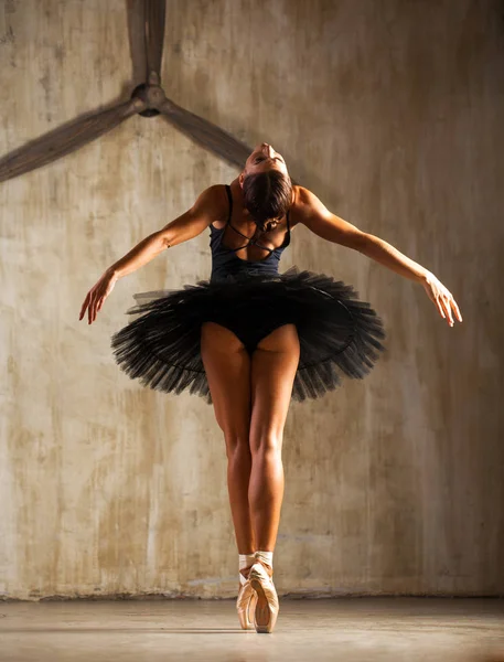 Jovem bela bailarina em preto tutu balé posando em st escuro — Fotografia de Stock