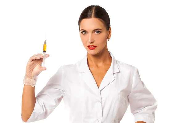 Jovem enfermeira de casaco branco segura uma seringa em suas mãos — Fotografia de Stock