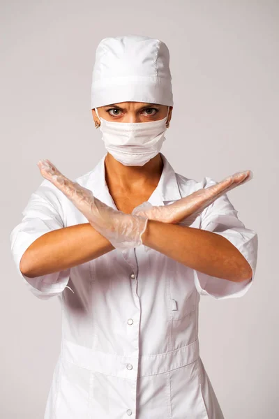 灰色の背景に隔離された白いスーツを着た看護師 — ストック写真