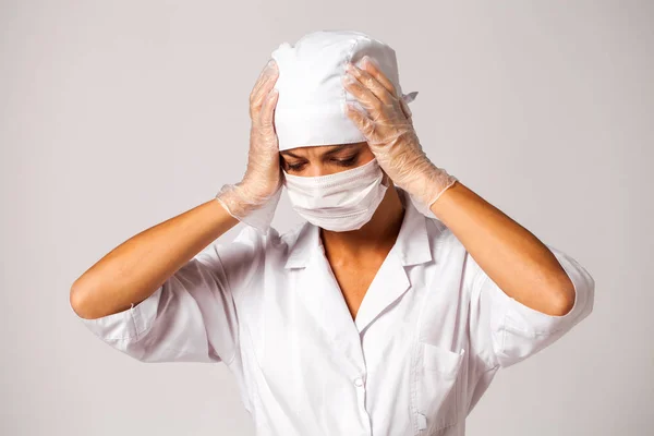 Ošetřovatelka v bílém obleku izolovanému na šedém pozadí — Stock fotografie