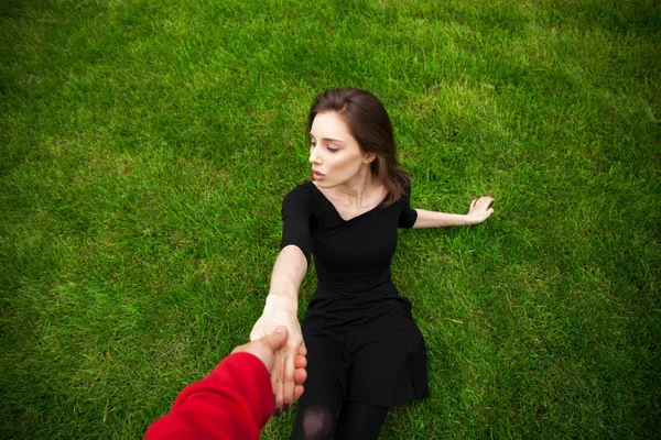 Retrato de vista superior de una joven hermosa mujer en vestido negro se encuentra — Foto de Stock