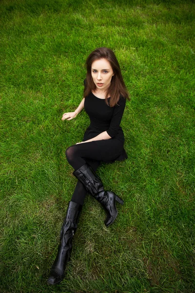 Retrato de vista superior de una joven hermosa mujer en vestido negro se encuentra —  Fotos de Stock