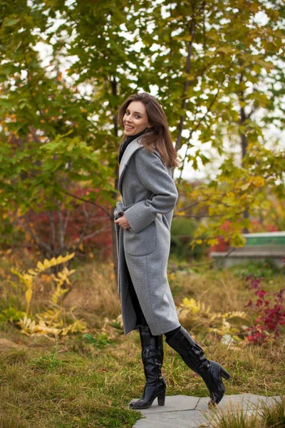 Porträt einer jungen schönen Frau im grauen Mantel, die im Herbst posiert — Stockfoto