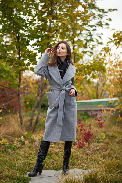 Portret młodej pięknej kobiety w szarym płaszczu stwarzające jesienią — Zdjęcie stockowe