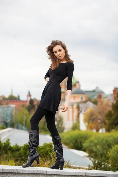 Retrato de una joven hermosa mujer en vestido negro posando en autum — Foto de Stock