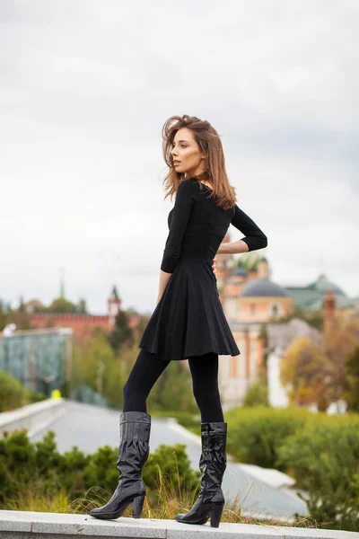 Portret van jonge mooie vrouw in zwarte jurk poseren in Autum — Stockfoto