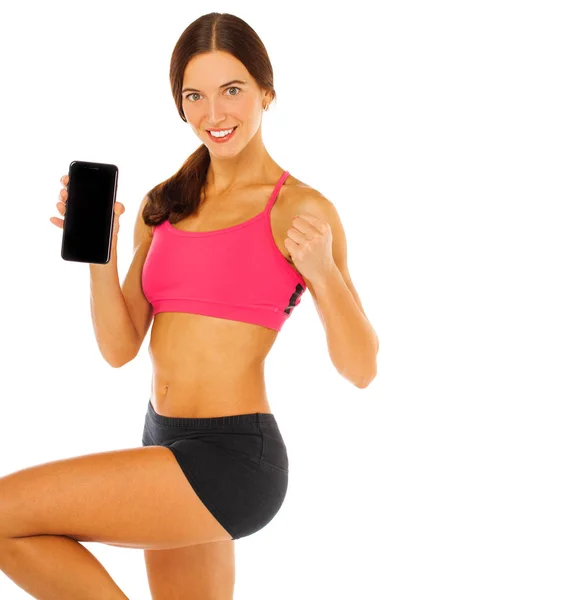 Fröhliche junge Fitness-Frau zeigt leeren Smartphone-Bildschirm iso — Stockfoto