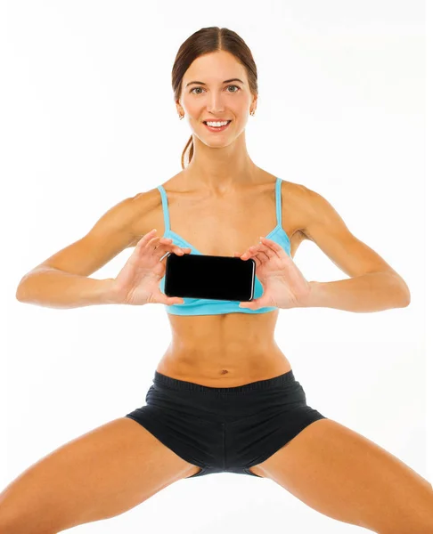 Joyeux jeune femme de remise en forme montrant écran blanc smartphone iso — Photo