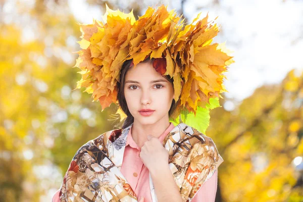 幸せな若いです美しいです女の子とともにカエデの葉の花輪で秋 — ストック写真