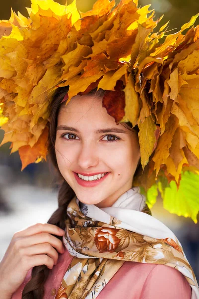 Jovem menina bonita feliz com uma grinalda de folhas de bordo em autu — Fotografia de Stock