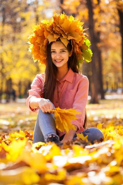 Happy young beautiful girl with a wreath of maple leaves in autu — Stock Photo, Image