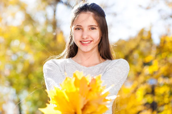 Hübsche brünette kleine Mädchen posiert im Herbst Park Hintergrund — Stockfoto