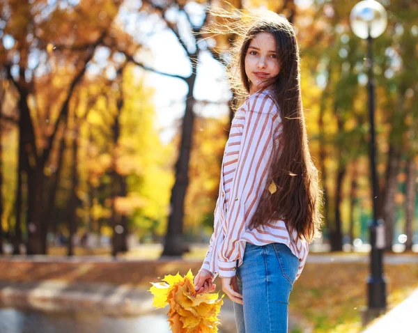 Menina morena bonita posando no fundo do parque de outono — Fotografia de Stock