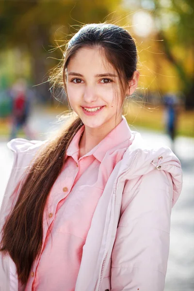 Linda niña morena posando en el fondo del parque de otoño —  Fotos de Stock