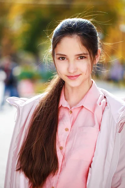 Linda niña morena posando en el fondo del parque de otoño —  Fotos de Stock