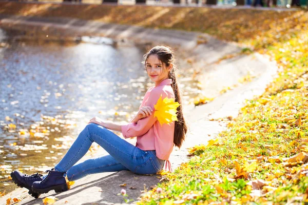 Jolie petite fille brune posant en arrière-plan de parc d'automne — Photo