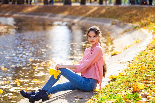 Linda niña morena posando en el fondo del parque de otoño —  Fotos de Stock