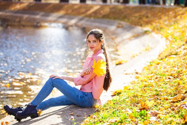 Ładna brunetka dziewczynka pozuje w jesiennym parku tle — Zdjęcie stockowe