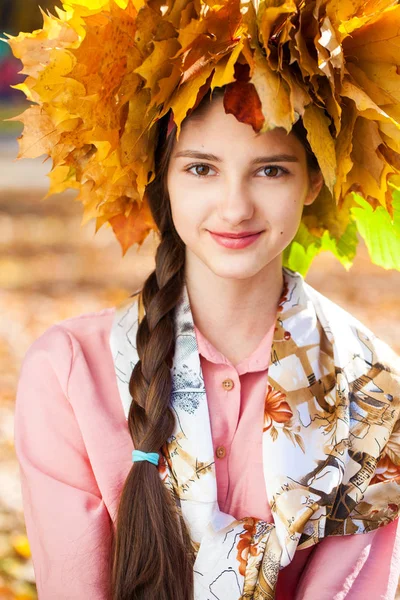 Felice giovane bella ragazza con una corona di foglie d'acero in autu — Foto Stock