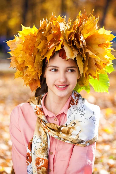 幸せな若いです美しいです女の子とともにカエデの葉の花輪で秋 — ストック写真