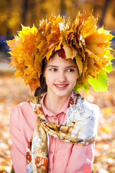 Happy young beautiful girl with a wreath of maple leaves in autu — Stock Photo, Image