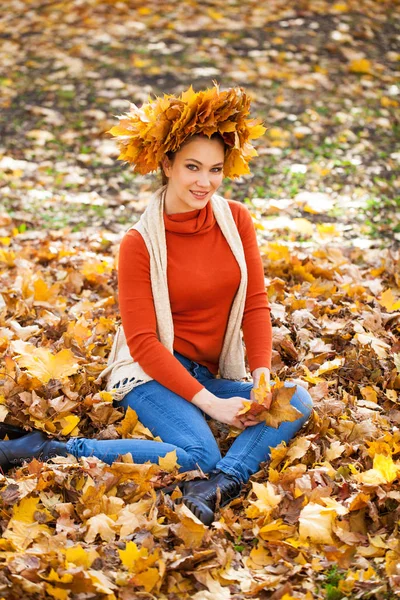 Junge schöne Frau mit einem Kranz aus Ahornblättern posiert in au — Stockfoto