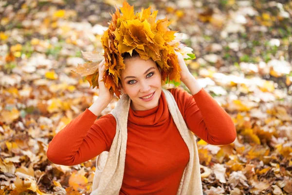 Jeune belle femme avec une couronne de feuilles d'érable posant au — Photo