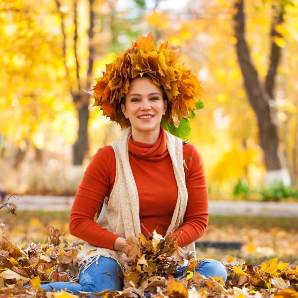 Young beautiful woman with a wreath of maple leaves posing in au — Stock Photo, Image