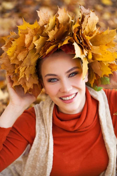 Jeune belle femme avec une couronne de feuilles d'érable posant au — Photo