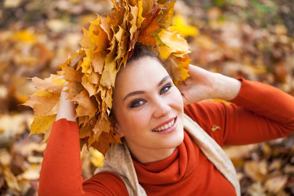 Jovem mulher bonita com uma coroa de folhas de bordo posando em au — Fotografia de Stock