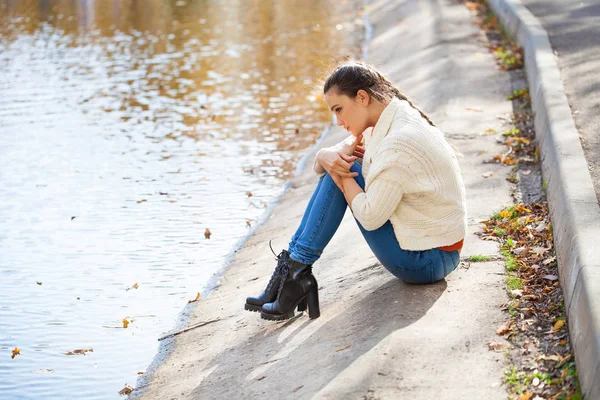 Giovane bella donna in jeans blu in posa nel parco autunnale — Foto Stock