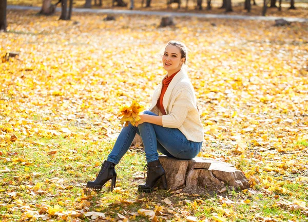 Jovem mulher bonita em jeans azul posando no parque de outono — Fotografia de Stock