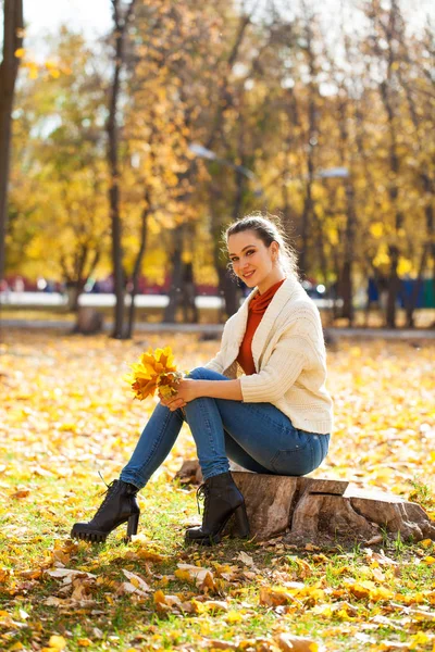Joven hermosa mujer en jeans azules posando en el parque de otoño — Foto de Stock