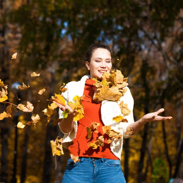 Młoda piękna kobieta w niebieskich dżinsach pozuje w jesiennym parku — Zdjęcie stockowe