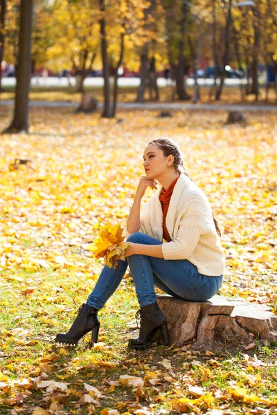 Joven hermosa mujer en jeans azules posando en el parque de otoño — Foto de Stock