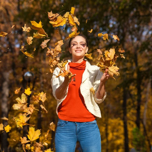 Junge schöne Frau in blauen Jeans posiert im Herbstpark — Stockfoto