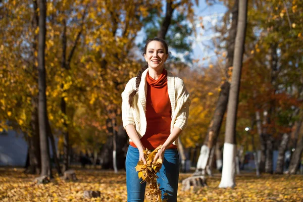 Ung vacker kvinna i blå jeans poserar i höstparken — Stockfoto