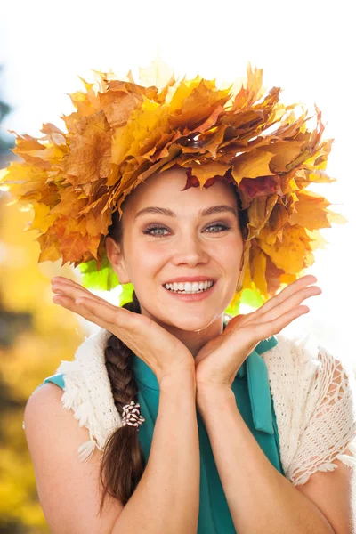 Joven hermosa mujer con una corona de hojas de arce posando en au — Foto de Stock