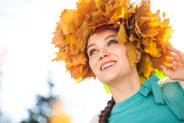 Jeune belle femme avec une couronne de feuilles d'érable posant au — Photo