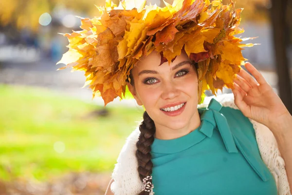 Jonge mooie vrouw met een krans van esdoorn bladeren poseren in au — Stockfoto