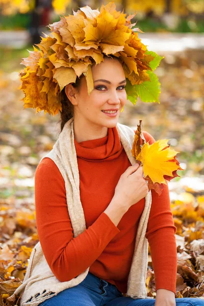 Young beautiful woman with a wreath of maple leaves posing in au Stock Picture