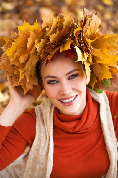 Young beautiful woman with a wreath of maple leaves posing in au Stock Image