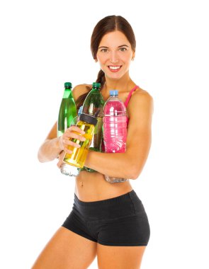 Genç atletik model bir sürü su şişesi tutuyor. 