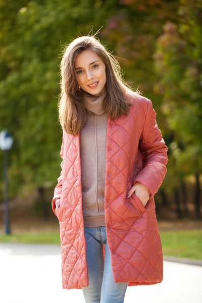 Mulher elegante jovem em um salmão jaqueta posando em um backgrou — Fotografia de Stock